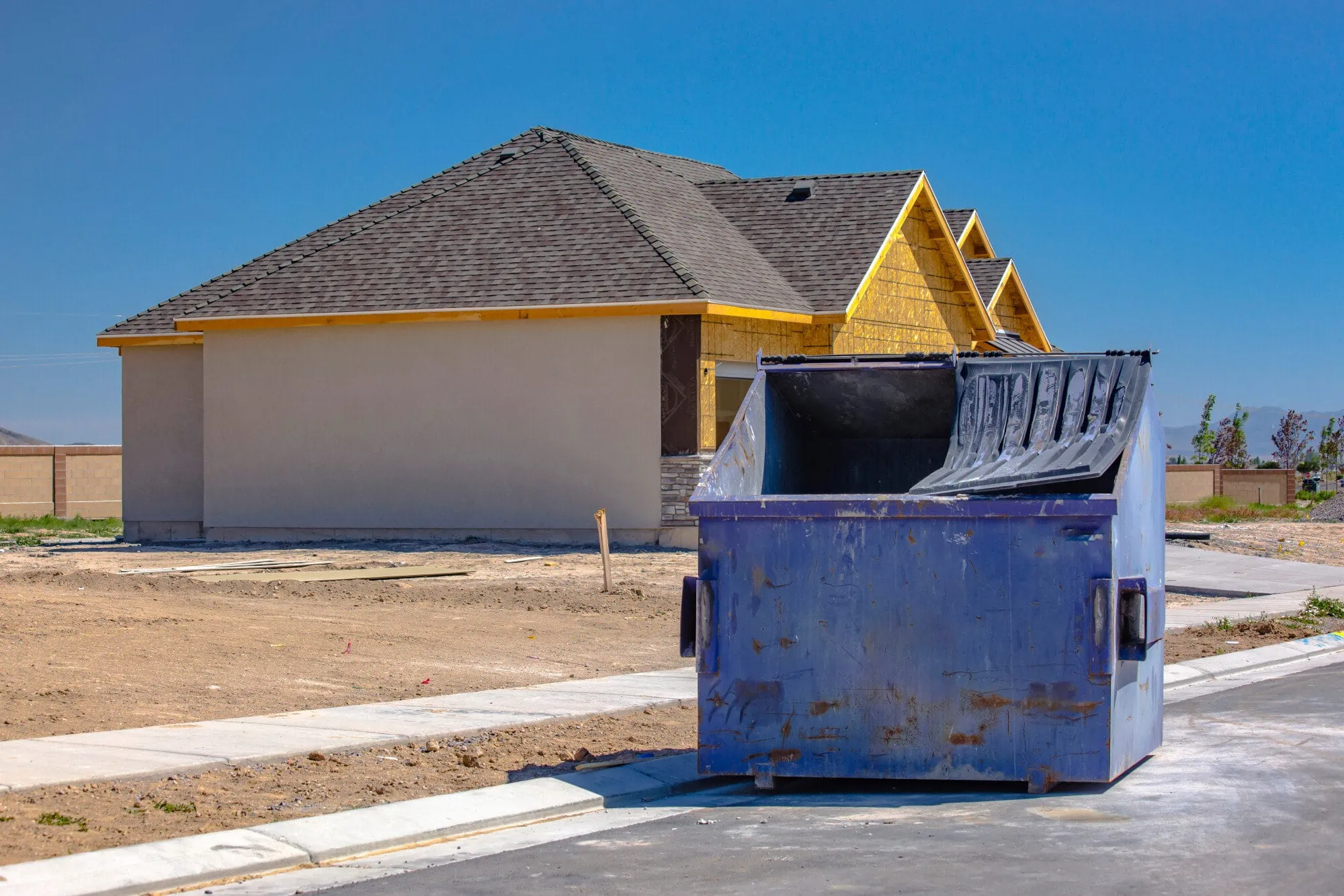 Blue Dumpster in front of house construction